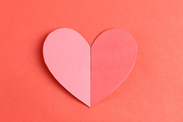 Heart shape of paper on the red cardboard background. - Photo, image