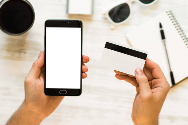holding hand credit card and using smartphone. A black smartphone mock up and a credit card in the hands of Closeup photo businessman Online payments plastic card. Horizontal mockup - Photo, Image