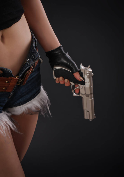 Close up of sexy girl with gun in hand - Foto, Imagen