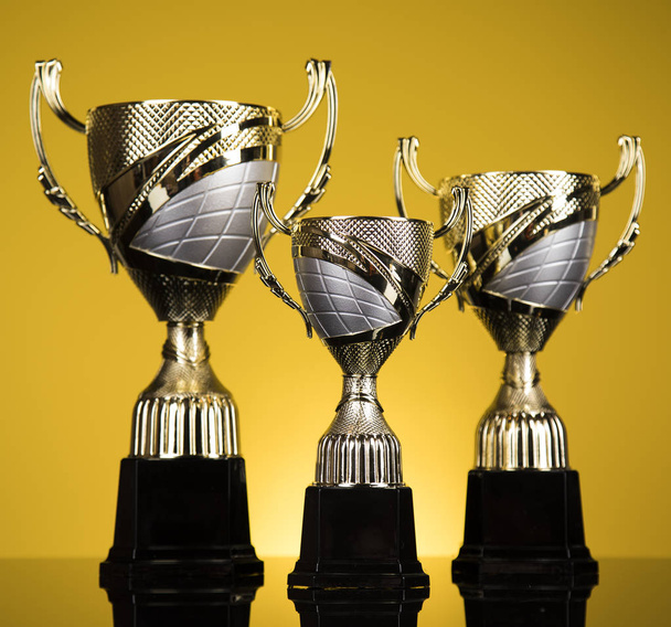 Vítězný a mistrovský koncept, pohár trofeje na sportovním pozadí - Fotografie, Obrázek