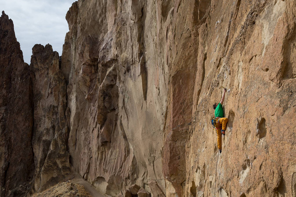 Авантюрним людина є рок сходження на стороні крутої скелі під час похмурі зимові вечір. Прийняті в Сміт рок, штат Орегон, Північна Америка. - Фото, зображення