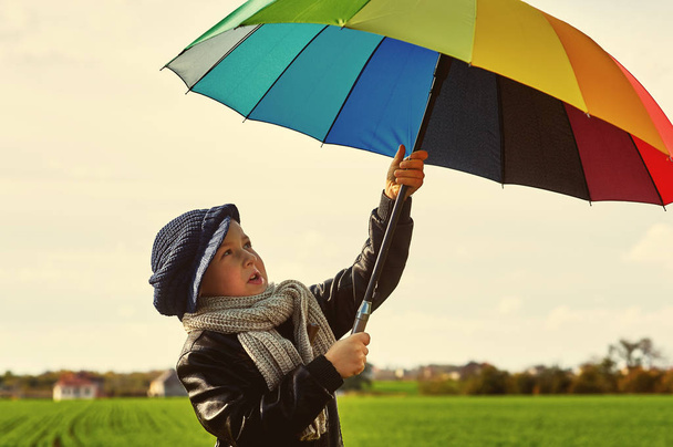 Garçon sur le terrain avec un parapluie coloré lumineux. L'enfant aime la nature
 - Photo, image