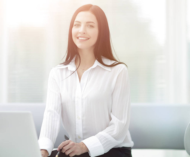 successful young woman sitting at a desk on a blurred background - Foto, immagini