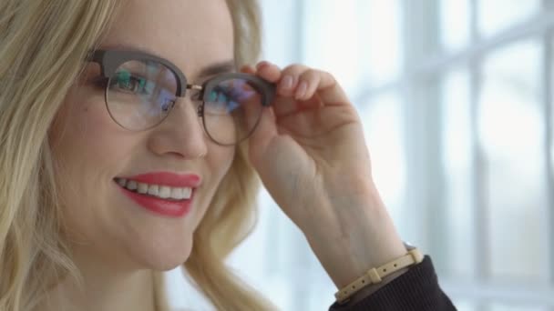 Close-up of a young beautiful woman with glasses at the window - Video