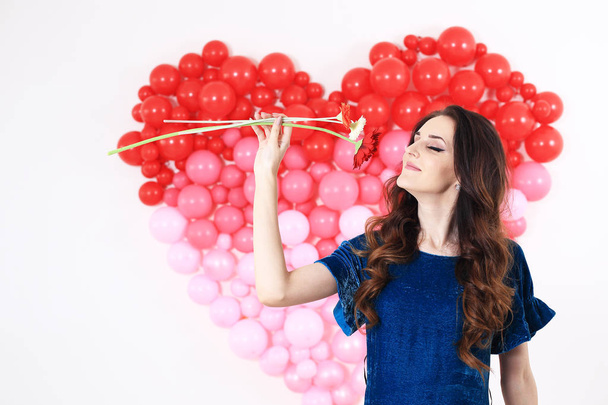 Seksikäs brunette nainen punainen sydän ilmapalloja ja kukkia
 - Valokuva, kuva