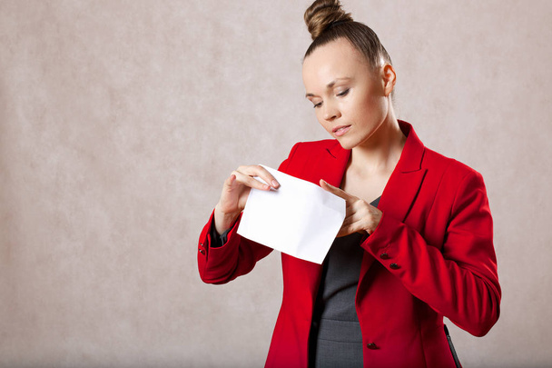A jovem caucasiana guarda um envelope. Fechar.
 - Foto, Imagem
