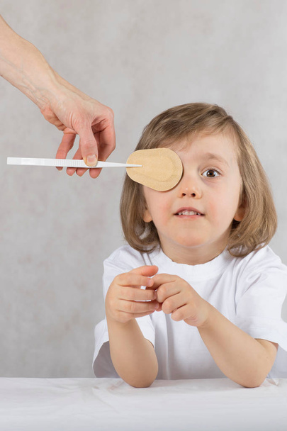Oftalmólogo cierra los ojos del niño con almohadilla ocular
.  - Foto, imagen