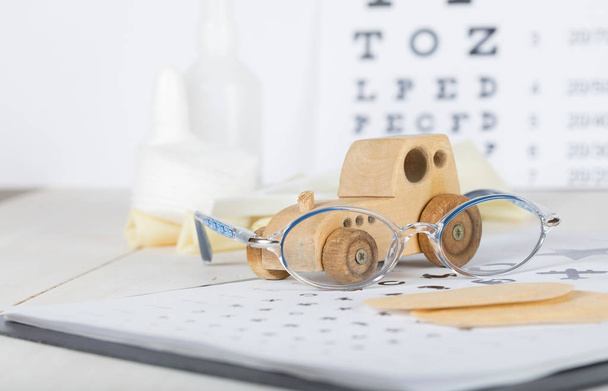 Eyeglasses for children on a eye chart close to eye pads.  - Photo, Image