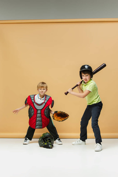 Two happy children show different sport. Studio fashion concept. Emotions concept. - Foto, afbeelding