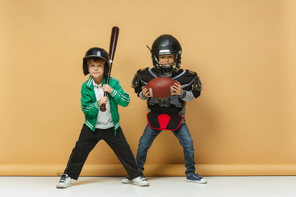 Two happy children show different sport. Studio fashion concept. Emotions concept. - Фото, изображение