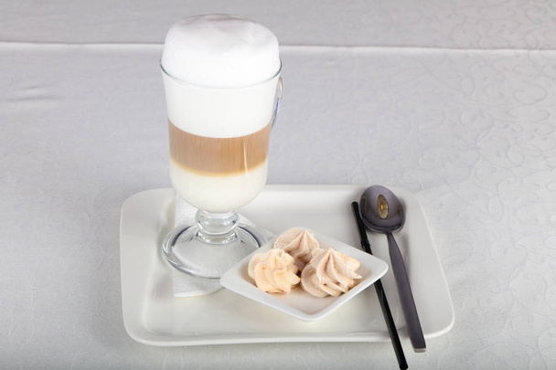Lasi Latte kahvia valkoisella pöydällä
 - Valokuva, kuva