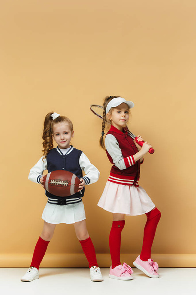Two happy and beautyful children show different sport. Studio fashion concept. Emotions concept. - Fotoğraf, Görsel