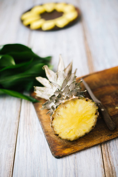 Sliced fresh pineapple on a wooden background in sunlight - Photo, Image