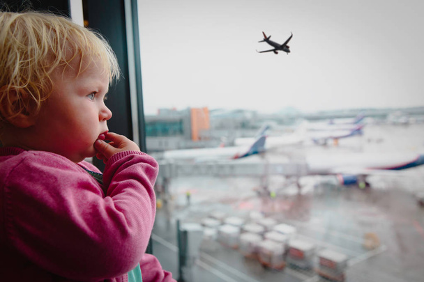 concepto de viaje- bebé mira aviones en el aeropuerto
 - Foto, imagen