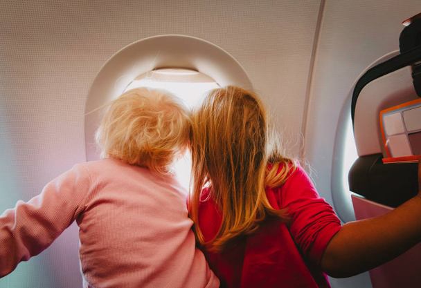 子供の飛行機旅行 - 飛行のウィンドウに探している女の子 - 写真・画像