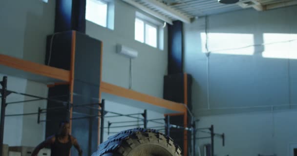 Homem pulando sobre pneu grande durante o treinamento
 - Filmagem, Vídeo