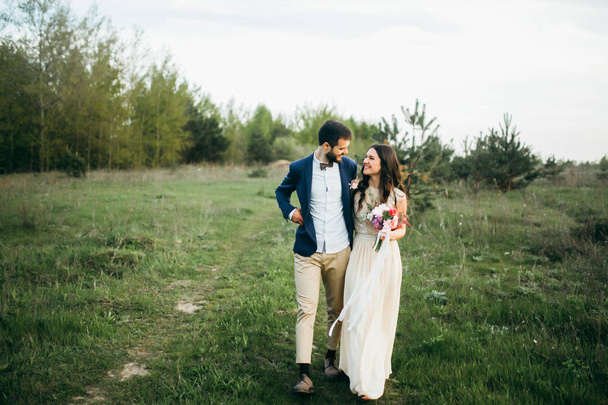 young couple of newlyweds walking in park  - Фото, изображение