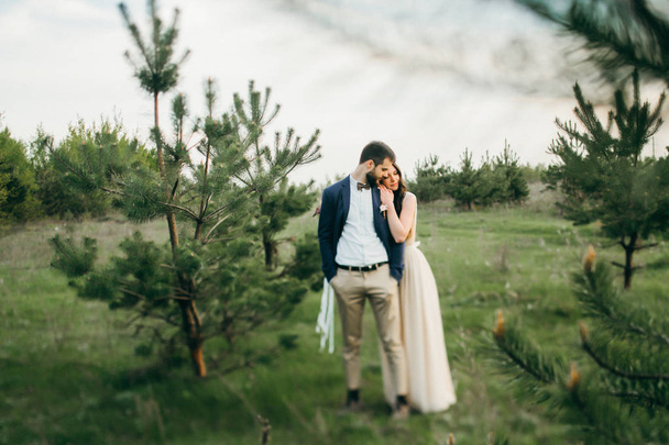 happy young bride and groom embracing outdoors  - Zdjęcie, obraz