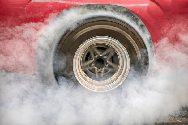 Arrastre coche de carreras quema caucho de sus neumáticos en preparación para la carrera - Foto, imagen