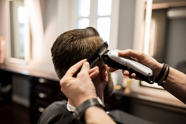Customer having hair shaved at barber shop - Фото, зображення