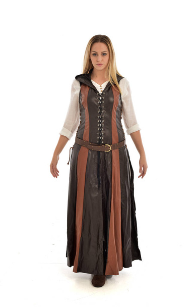 full length portrait of girl wearing brown leather medieval costume, standing pose, isolated on white studio background. - Фото, изображение