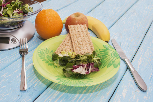 köstlicher Salat aus grünen Kräutern auf einem Teller, Küchenwaage. das Konzept der richtigen Ernährung. Ernährung - Foto, Bild