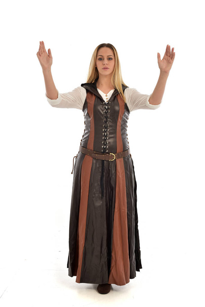po celé délce portrét dívky nosí hnědý kožený středověký kostým, stojící pozice, izolované na bílém studio pozadí. - Fotografie, Obrázek