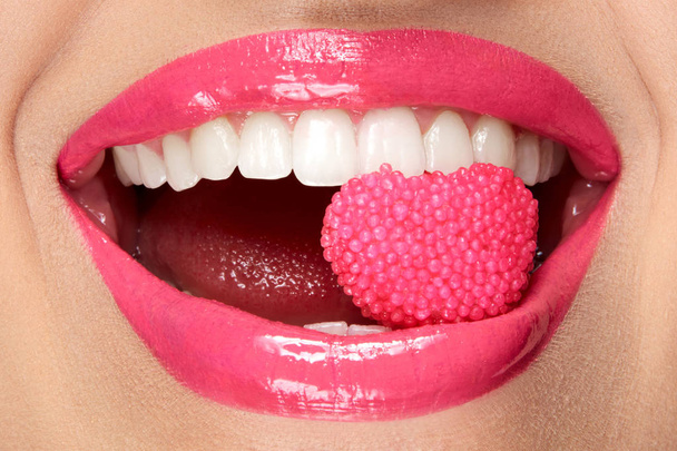 Розовые губы. Женщина с конфеткой во рту
. - Фото, изображение