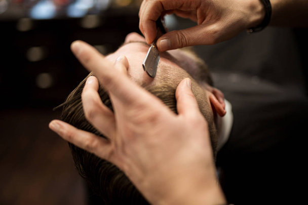 Customer being shaved by professional barber - Φωτογραφία, εικόνα