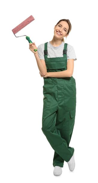 Young female decorator with paint roller on white background - Foto, afbeelding