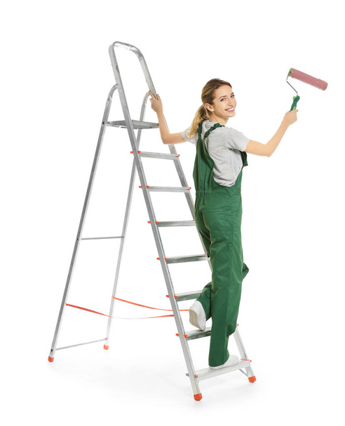 Young female decorator with paint roller on white background - Foto, Imagen