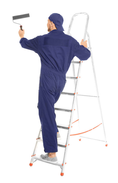 Young male decorator with paint roller on white background - Foto, Imagem