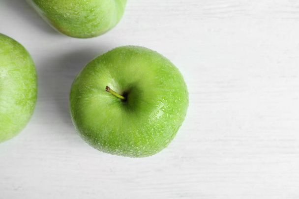 Fresh green apples with water drops on white table, top view - Fotoğraf, Görsel