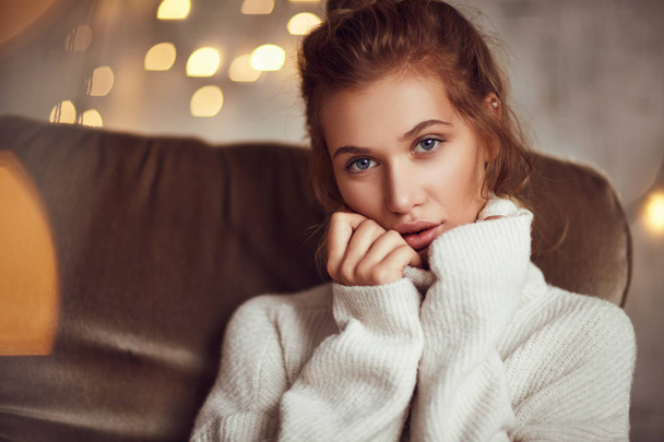 ソファの上のセーターの女性 - 写真・画像