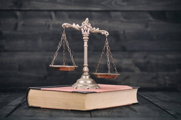  Κλίμακες της δικαιοσύνης και του δικαίου βιβλία σε φόντο ξύλινη. - Φωτογραφία, εικόνα