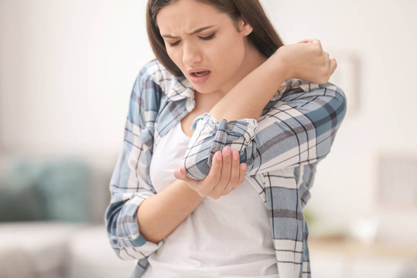 Młoda kobieta cierpi na ból łokcia w domu - Zdjęcie, obraz