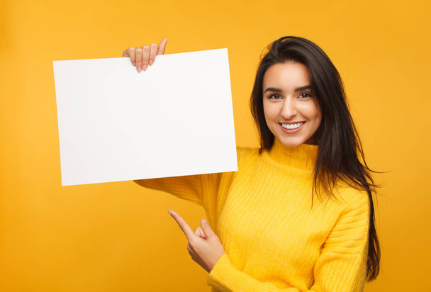 Charming brunette pointing at blank paper - Foto, immagini