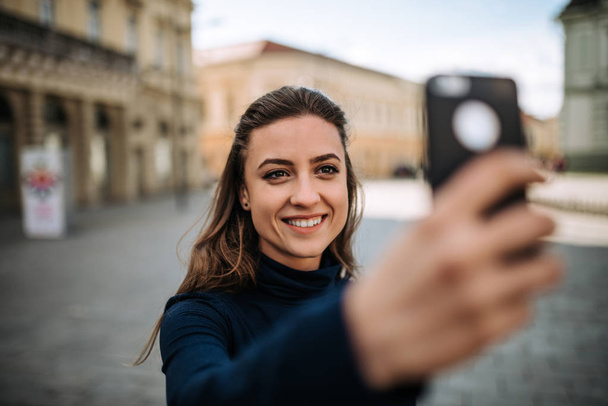 Young woman making a selfie in the city - Valokuva, kuva
