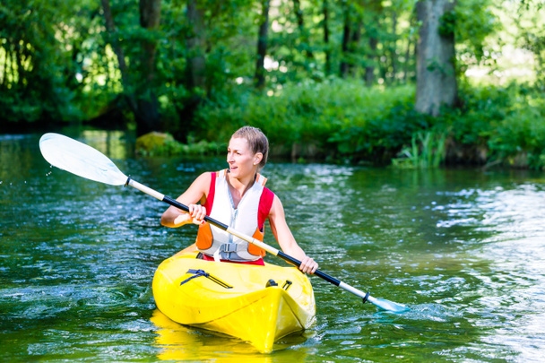 Vrouw met kano peddelen op bos rivier - Foto, afbeelding