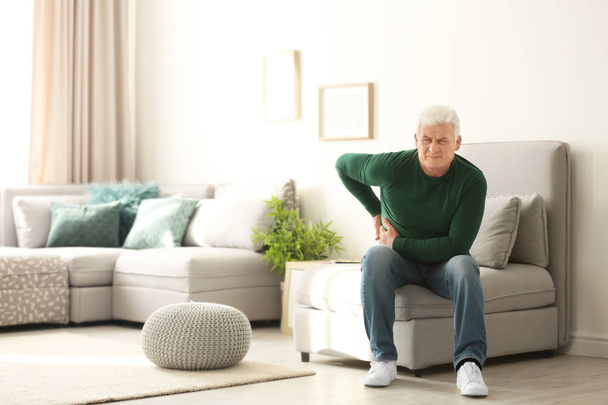 Mature man suffering from back pain at home - Valokuva, kuva