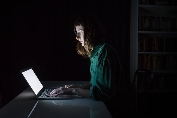 Woman works at laptop computer late in the evening - Фото, зображення