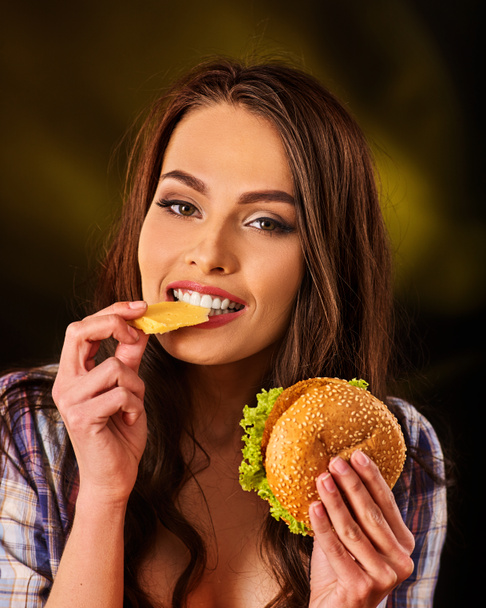 Nő francia krumplit és a hamburgert eszik a táblázat. - Fotó, kép