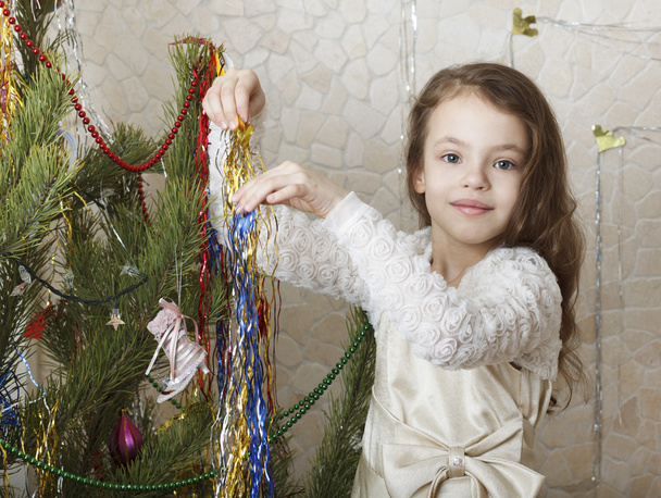 όμορφο κορίτσι στολίζει το χριστουγεννιάτικο δέντρο. - Φωτογραφία, εικόνα