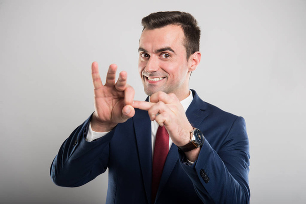 Привлекательный бизнесмен показывает пальцем весь жест
 - Фото, изображение