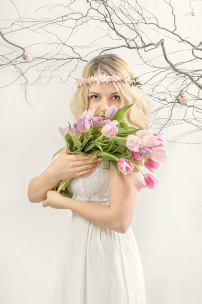 Portrait of a young woman in a wreath of flowers. Spring concept - Foto, Imagen