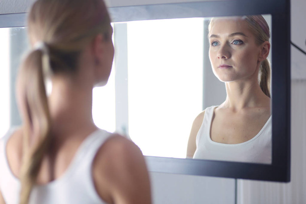 face of young beautiful healthy woman and reflection in the mirror - Foto, afbeelding