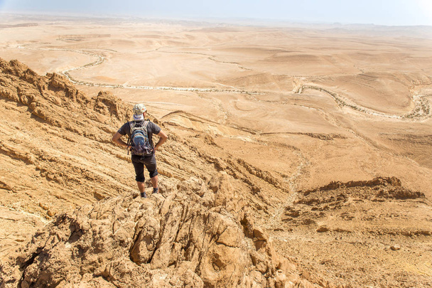 Backpacker τουρίστας που στέκεται έρημο βράχο κορυφογραμμή άκρη lan - Φωτογραφία, εικόνα