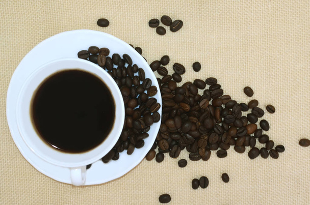 Φλιτζάνι καφέ και κόκκους καφέ σε φυσικό λινό φόντο. Το Top view. - Φωτογραφία, εικόνα