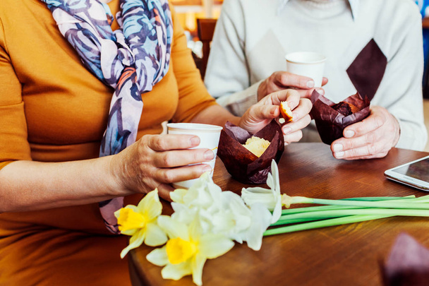 Senior paar houdt handen in het café koffie drinken. Verjaardag vieren. - Foto, afbeelding