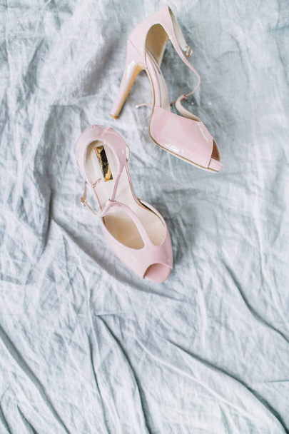 Pink female high heel shoes on textile background. Flat lay, top view - 写真・画像